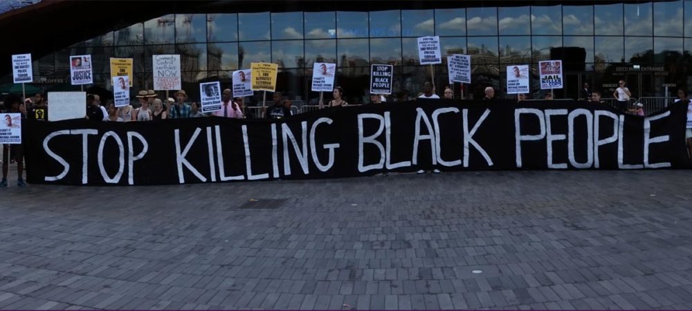People holding banner at a Black Lives Matter event in Brooklyn, NY