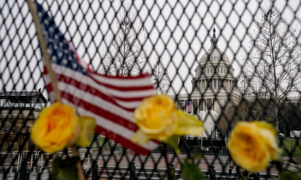 透过插满鲜花和美国国旗的栅栏可以看到美国国会大厦