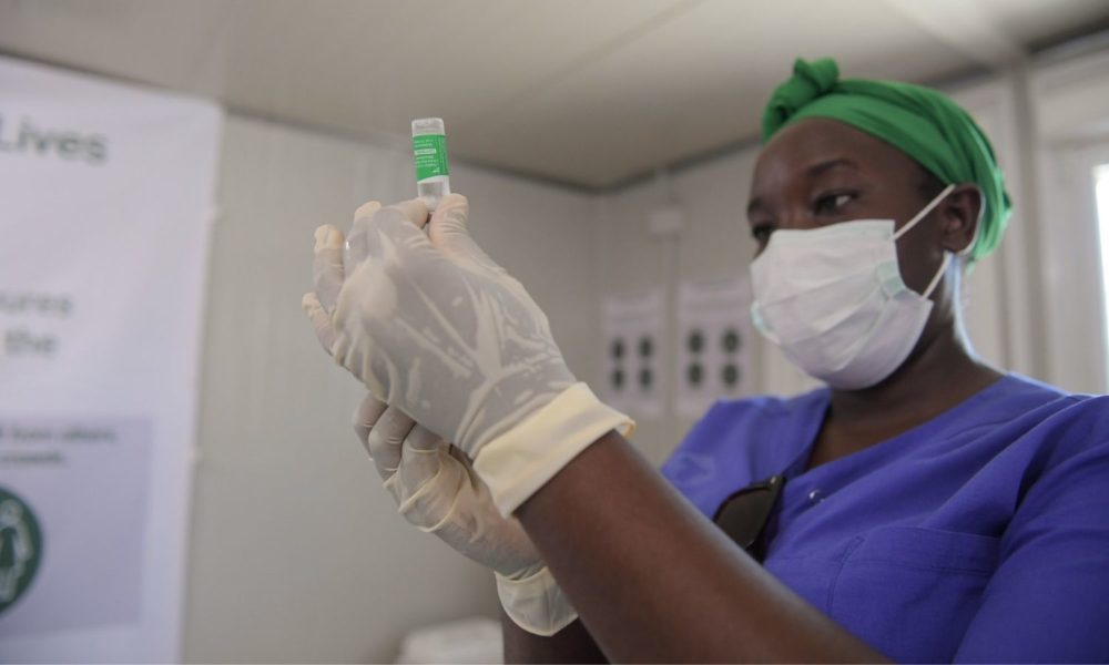 在索马里摩加迪沙的一家医院里，一名戴着头巾、口罩和橡胶医用手套的妇女手持一瓶COVID-19疫苗