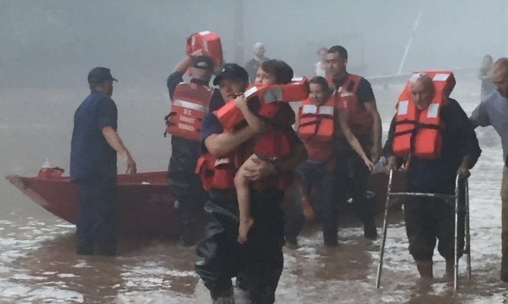 美国海岸警卫队成员为受洪水影响的西弗吉尼亚州居民提供救生衣。