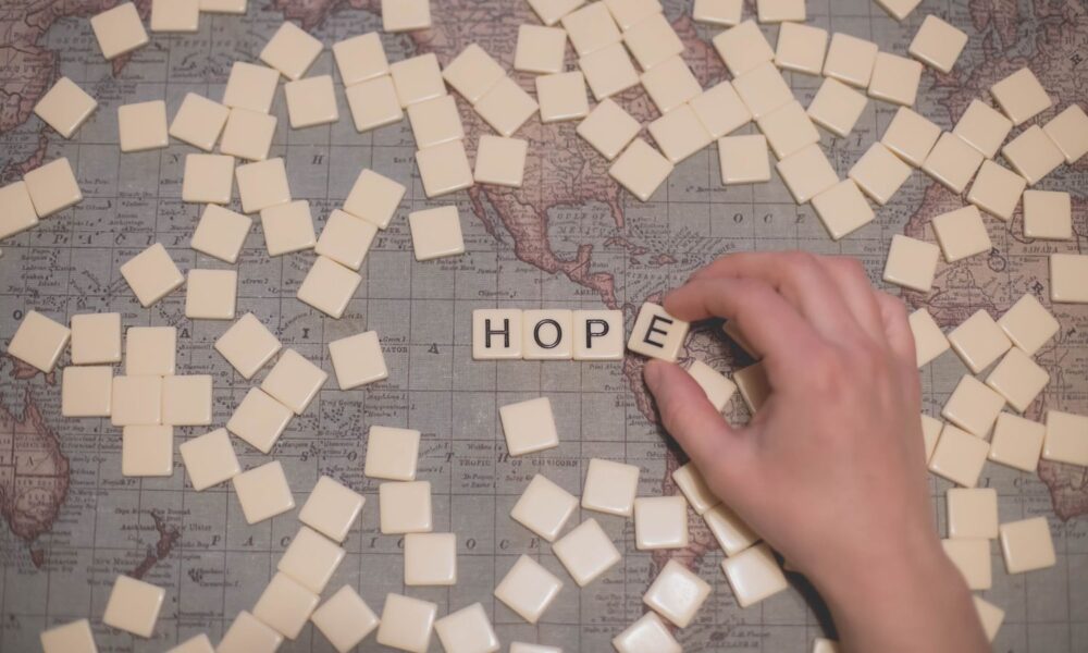 一张世界地图，上面有一堆拼字游戏。看得见的字母拼出“HOPE”
