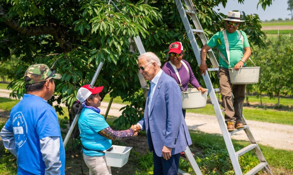 乔·拜登总统在密歇根州中央湖向农场工人致意。
