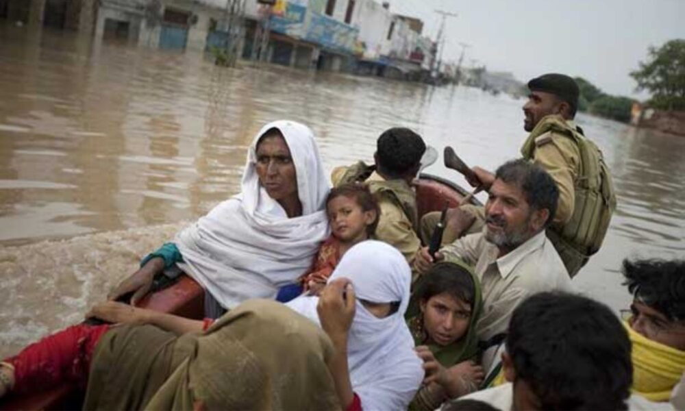 在巴基斯坦瑙谢拉，当道路被洪水淹没时，士兵们沿着主要道路疏散一个家庭