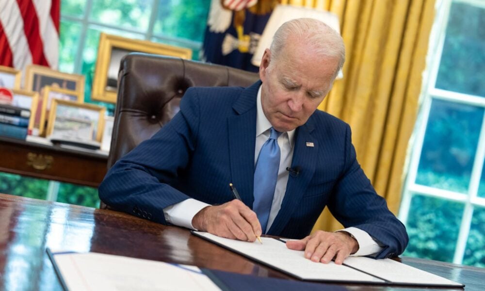 President Biden sits at his desk in the Oval Office, signing a veto for (unrelated) legislation in June 2023.