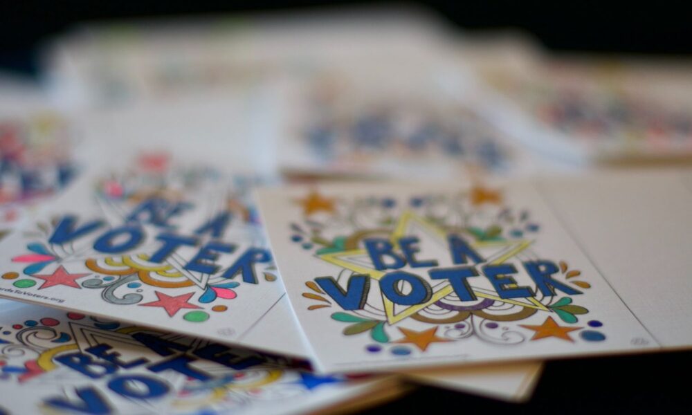 A pile of colorful postcards that read BE A VOTER in block letters, with a fun and cheerful star pattern around the text